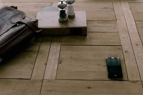 cell phone black smartphone beside brown leather bag mobile phone